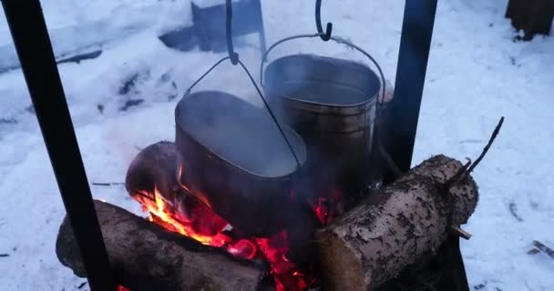 火鍋のスープを調理します。お茶のための水として融雪します。冬の森でのキャンプ. — ストック動画