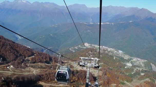 Rosa-Khutor, Ρωσία-13 Οκτωβρίου 2018. Μετακίνηση καμπίνες του δρόμου καλώδιο. Τελεφερίκ που κινείται πάνω από τα δέντρα στις πλαγιές των βουνών. — Αρχείο Βίντεο