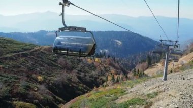 Rosa-Khutor, Rusya-13 Ekim 2018. Kablo yolun kabin hareket. Füniküler dağların yamaçlarında ağaçların üzerinden hareket.
