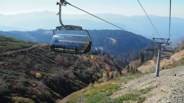 Rosa-Khutor, Ρωσία-13 Οκτωβρίου 2018. Μετακίνηση καμπίνες του δρόμου καλώδιο. Τελεφερίκ που κινείται πάνω από τα δέντρα στις πλαγιές των βουνών. — Αρχείο Βίντεο