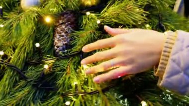 Kadın felç Noel çelenk çam ağacı dalları çam kozalakları ve ampuller ile yapılmış. Yeni yıl arka plan.