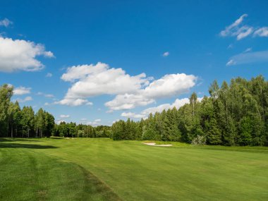 Kırsal golf sahası. Yeşil alan, orman ve mavi gökyüzü düzenlenen çimde. Cennet güneşli gün. Rusya.