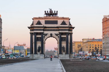 Moskova, Rusya - 24 Mart 2007. Genç çift Poklonnaya hill yakınındaki 1812 yılın savaş adanmış zafer takı önünde öpüyor. Kutuzovskiy prospekt üzerinde trafik. 