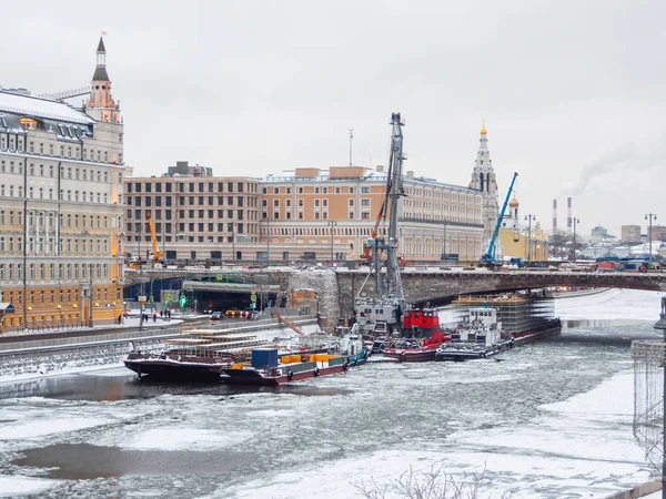 建設機械が付いている船は モスクワ川 橋の下でボリショイ Moskvoretsky 橋の復興 モスクワ ロシアの冬曇りの日 — ストック写真