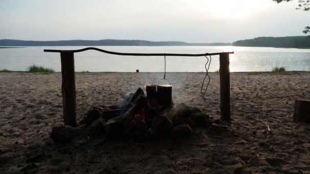 Vaření polévky na hrnec požáru. Letní kemp na pláži. Kenozero národní park, Rusko. — Stock video