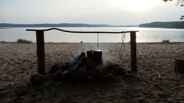 Cocinar sopa en una olla de fuego. Camping de verano en la playa. Parque nacional Kenozero, Rusia . — Vídeos de Stock