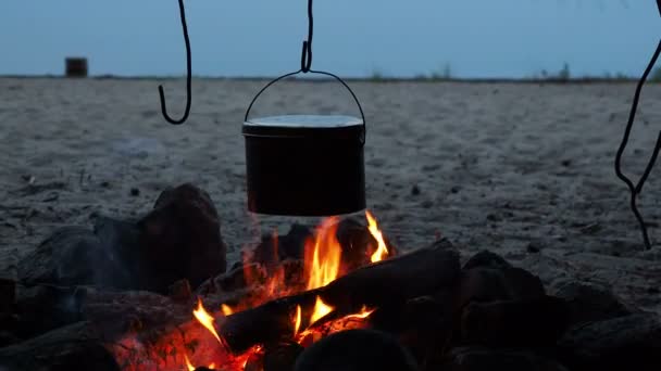 Cocinar sopa en una olla de fuego. Camping de verano en la playa. Parque nacional Kenozero, Rusia . — Vídeo de stock