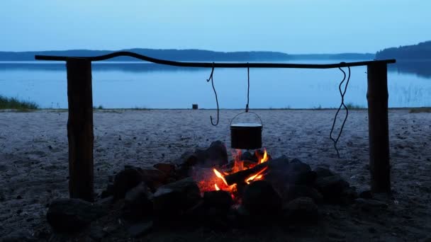 Cocinar sopa en una olla de fuego. Camping de verano en la playa. Parque nacional Kenozero, Rusia . — Vídeo de stock