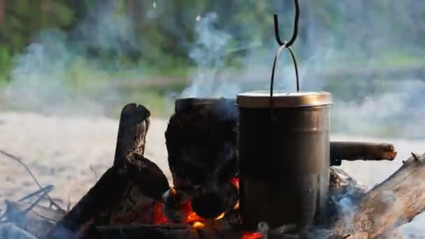 Cocinar sopa en una olla de fuego. Camping de verano en la playa. Parque nacional Kenozero, Rusia . — Vídeo de stock