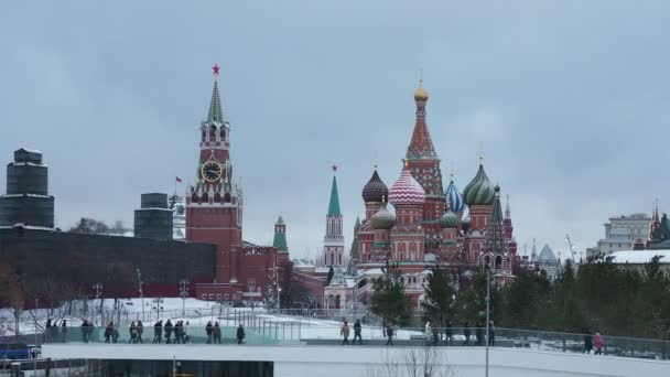 MOSCOW, RUSSIA - December 12, 2018. Famous landmarks - St. Basil Cathedral on Red square in Kremlin and Zaryadie park with walking tourists. — Stock Video