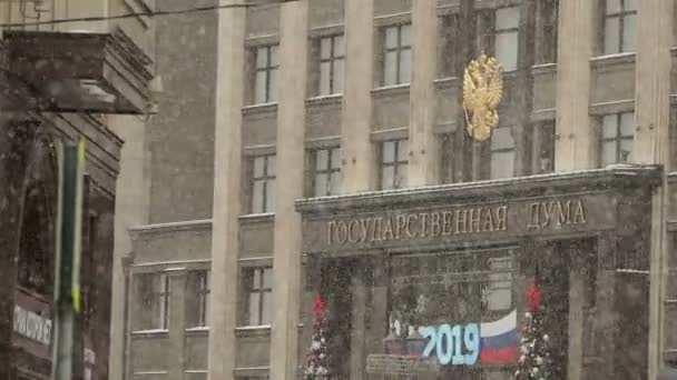Staats doema. Ingang van gebouw ingericht voor Nieuwjaar 2019 viering. Sneeuwval. Moskou, Rusland. — Stockvideo