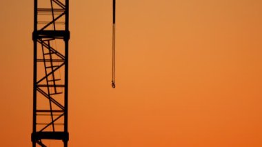 Arka planda bir turuncu günbatımı inşaat vinç.