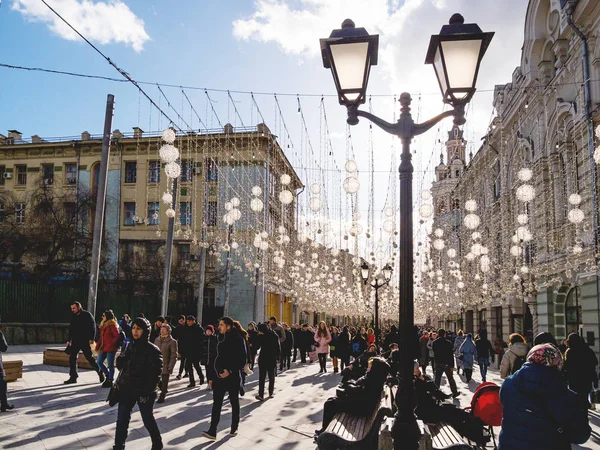 МОСКВА, РОССИЯ - 09 марта 2019 года. Местные жители и туристы ходят по знаменитой Никольской улице, украшенной лампочками . — стоковое фото