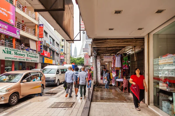 KUALA LUMPUR, MALASIA - 04 de febrero de 2013. Gente local y turistas en las calles de Kuala Lumpur. Muchos signos y anuncios en las paredes de los edificios . — Foto de Stock