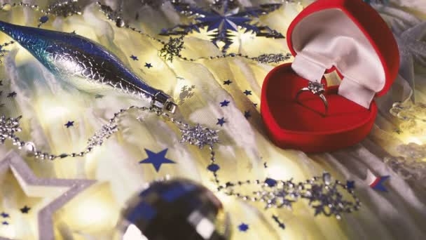 Різдвяний та новорічний фон з святковими прикрасами та діамантовим кільцем заручин у подарунковій коробці червоного серця . — стокове відео