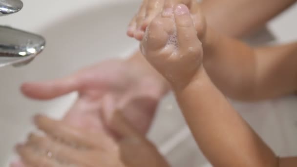 Mère aide son fils à nettoyer les mains de la pâte après la cuisson ensemble . — Video