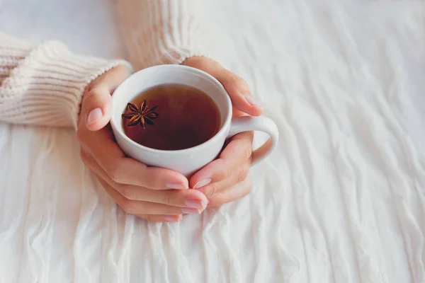 Vrouwen houdt een kop van hete thee met anijs ster. Gezellige ochtend thuis. — Stockfoto