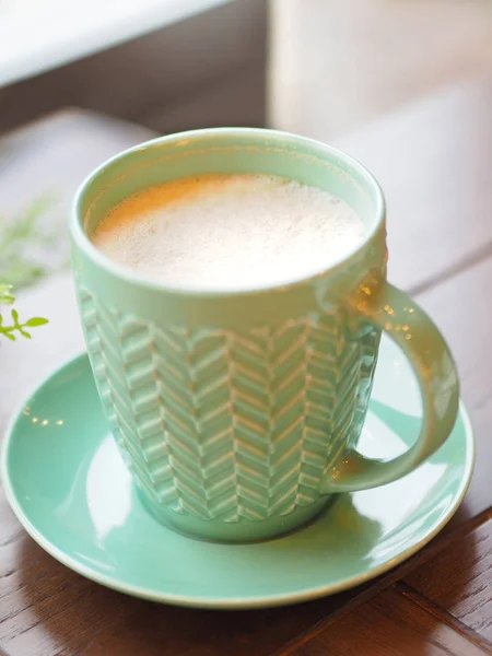 Porzellan Aquamarin farbige Tasse mit Cappuccino. Kaffeebecher auf Holztisch vorhanden. leckeres Heißgetränk. — Stockfoto