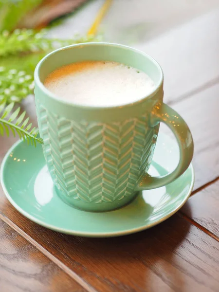 Porzellan Aquamarin farbige Tasse mit Cappuccino. Kaffeebecher auf Holztisch vorhanden. leckeres Heißgetränk. — Stockfoto