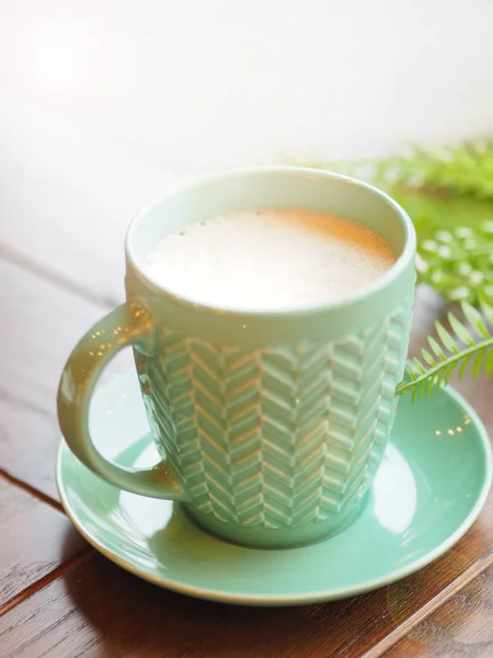 Porzellan Aquamarin farbige Tasse mit Cappuccino. Kaffeebecher auf Holztisch vorhanden. leckeres Heißgetränk. — Stockfoto