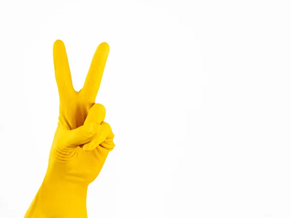 手在黄色橡胶手套显示 V 在白色背景。孤立的胜利姿态。良好清洁服务的标志. — 图库照片