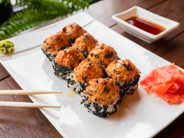 Rollos con anguila, hongos shiitake, sésamo negro, salsa picante, salsa unagi, jengibre en escabeche. Cocina asiática, plato tradicional - sushi . — Foto de Stock