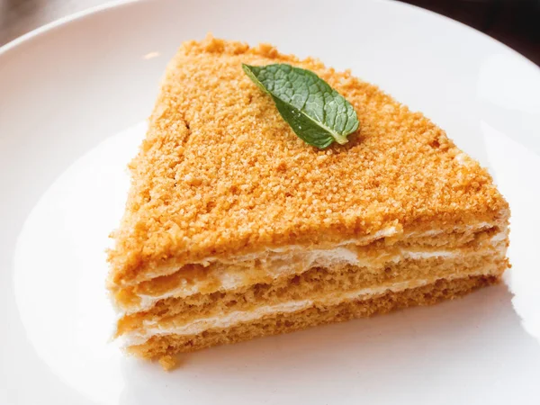 Белая тарелка с мёдом. Вкусный десерт со сметаной . — стоковое фото