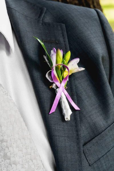 Бутоньерка с цветами и листьями фрезии. Традиционный аксессуар для жениха на свадьбе . — стоковое фото