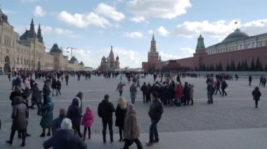 Moskova, Rusya - 09 Mart 2019. Ünlü St. Basils Katedrali ve Kremlin Spasskaya kulesi yakınında Kızıl Meydan'da yürüyen insanlar. Bahar kutlaması - Maslenitsa.
