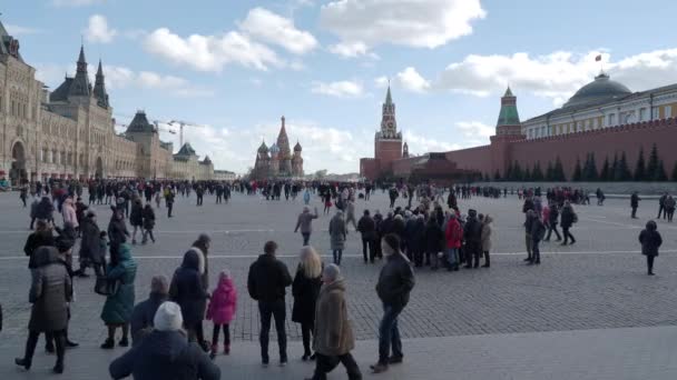 MOSCÚ, RUSIA - 09 de marzo de 2019. Gente caminando en la Plaza Roja cerca de la famosa Catedral de San Basilio y la torre Spasskaya del Kremlin. Celebración de primavera - Maslenitsa . — Vídeos de Stock