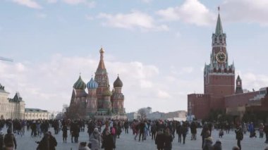 Moskova, Rusya - 09 Mart 2019. Ünlü St. Basils Katedrali ve Kremlin Spasskaya kulesi yakınında Kızıl Meydan'da yürüyen insanlar. Bahar kutlaması - Maslenitsa.