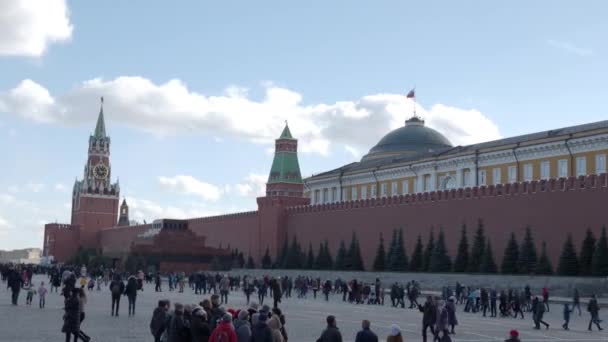 MOSCÚ, RUSIA - 09 de marzo de 2019. Gente caminando en la Plaza Roja cerca de la famosa Catedral de San Basilio y la torre Spasskaya del Kremlin. Celebración de primavera - Maslenitsa . — Vídeo de stock