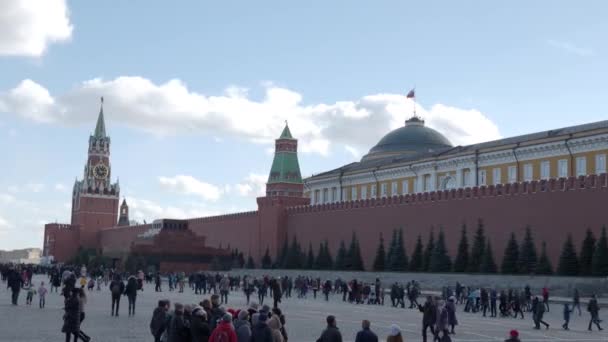 Moskou, Rusland-maart 09, 2019. Mensen lopen op het Rode plein in de buurt van de beroemde St. Basils kathedraal en Spasskaya toren van het Kremlin. Voorjaars viering-Maslenitsa. — Stockvideo