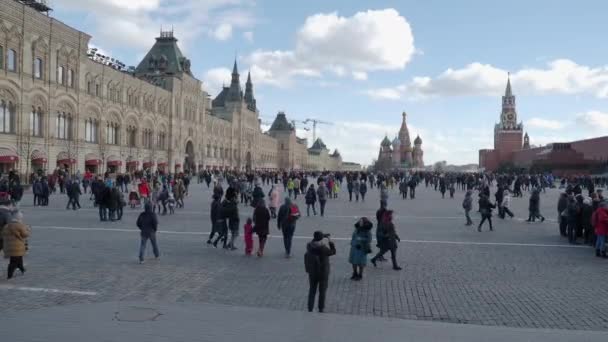 Moskova, Rusya - 09 Mart 2019. Ünlü St. Basils Katedrali ve Kremlin Spasskaya kulesi yakınında Kızıl Meydan'da yürüyen insanlar. Bahar kutlaması - Maslenitsa. — Stok video