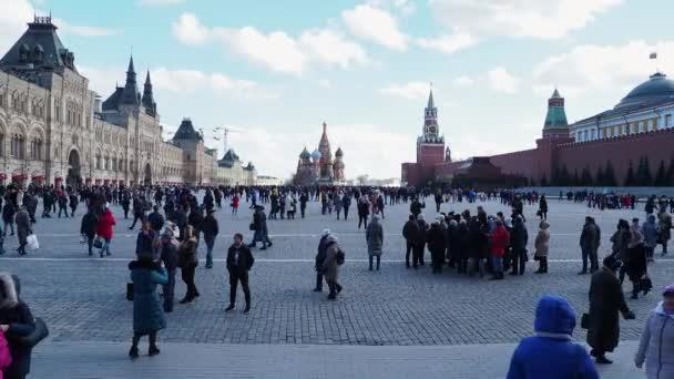 Moskova, Rusya - 09 Mart 2019. Ünlü St. Basils Katedrali ve Kremlin Spasskaya kulesi yakınında Kızıl Meydan'da yürüyen insanlar. Bahar kutlaması - Maslenitsa. — Stok video