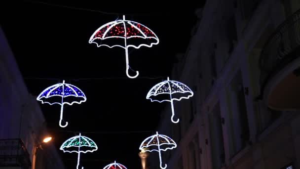 Outdoor decoration in shape of umbrellas. Cute colorful light bulbs twinkle in the dark. Yalta, Crimea. — Stock Video