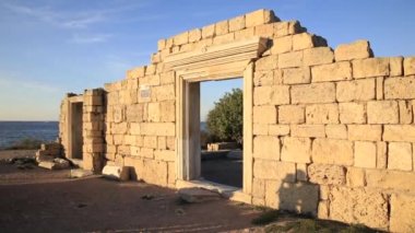 Aşık bir çift modern Sivastopol yakınlarındaki antik Yunan kasabası Chersonesus Bazilikası 'nın kalıntılarında fotoğraf çekip öpüşüyordu. Sonbahar günbatımında iki aşk kuşu. UNESCO Dünya Mirası Alanı. Kırım, Ukrayna.