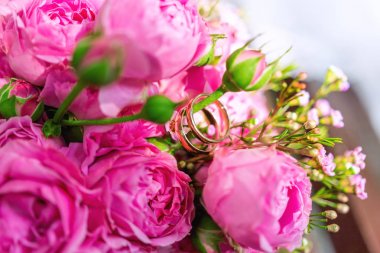 Pembe ve leylak gülile gelin buketi altın alyans. Düğün töreni için geleneksel çiçek kompozisyonu.