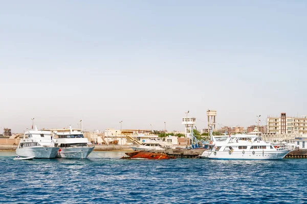 Hurghada Küste mit Hotels, Resort-Gebäuden und Schiffen, die an Pier festgemacht. Blick auf das Meer vom Boot aus. Rotes Meer, Ägypten. — Stockfoto