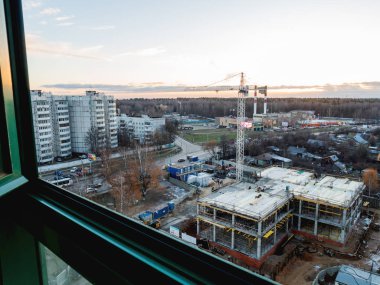 Krasnogorsk, Rusya - 21 Kasım 2018. Eski ahşap evler arasında şantiyede havadan görünüm. İşçiler tatilde. Beton takviye ve inşaat ekipmanları arasında turuncu üniformalı inşaatçılar. 