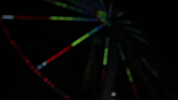 Város Ferris kerék díszített színes villogó fények. Fény show forgó körkörös lovagolni sötétedés után. Koncentrált, homályos. Krím. — Stock videók
