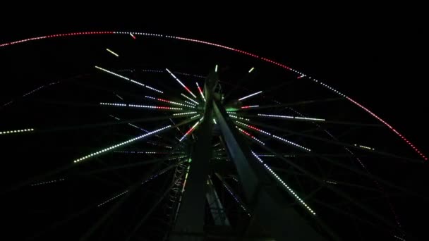 City Ferris wheel decorated with colorful flashing lights. Light show on spinning circular ride after dark. Crimea. — Stock Video