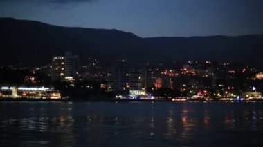 Karadeniz'den Yalta şehrinin panorama görünümü. Setüzerinde gece hayatı. Hareket eden tekneden görünüm. Kırım
