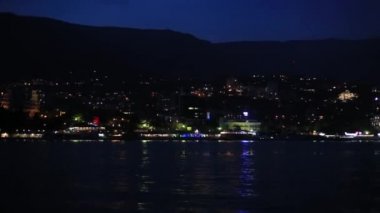 Karadeniz'den Yalta şehrinin panorama görünümü. Setüzerinde gece hayatı. Hareket eden tekneden görünüm. Kırım