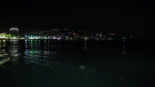 Панорама города Ялта с Черного моря. Ночная жизнь на набережной. Крым — стоковое видео