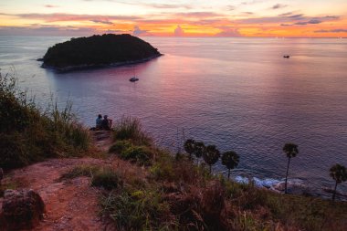 Kata plaj bakış noktasında muhteşem gün batımı. Çift deniz üzerinde tepede oturuyor. Ko Pu adası. Phuket, Tayland.