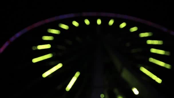 Roda gigante da cidade decorada com luzes coloridas piscando. Show de luz em girar passeio circular depois de escurecer. Desfocado, desfocado. República da Crimeia . — Vídeo de Stock