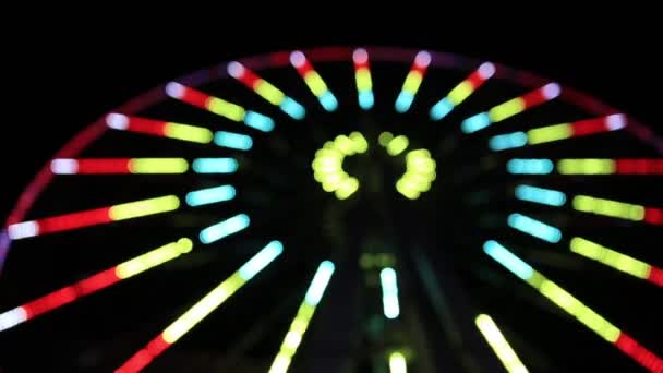 Rueda City Ferris decorada con luces intermitentes de colores. Espectáculo de luz en el paseo circular giratorio después del anochecer. Desenfocado, borroso. Crimea . — Vídeos de Stock