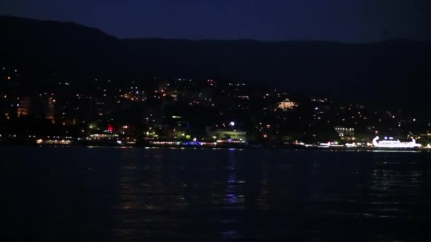 Vista panorámica de la ciudad de Yalta desde el mar Negro. Vida nocturna en terraplén. Vista desde el barco en movimiento.Crimea — Vídeos de Stock