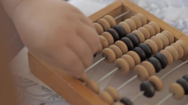 Toddler ahşap abaküs ile sayıyor. Bebek eski ahşap cihaz ile oynuyor. Çocuk saymayı öğreniyor. — Stok video